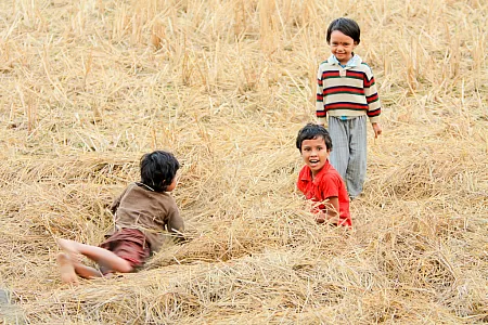 Kinder des Dorfes beim Spielen im Stroh